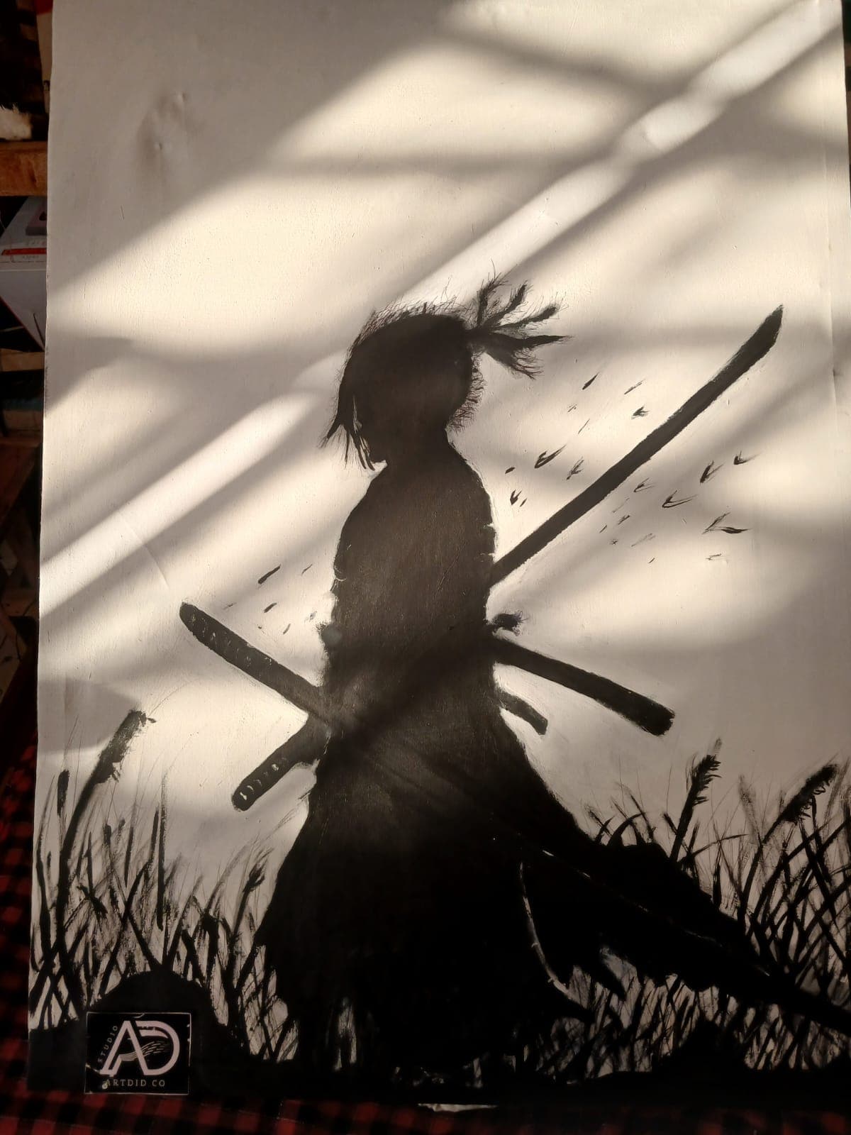Black silhouette painting of a samurai with two crossed swords walking through tall grass