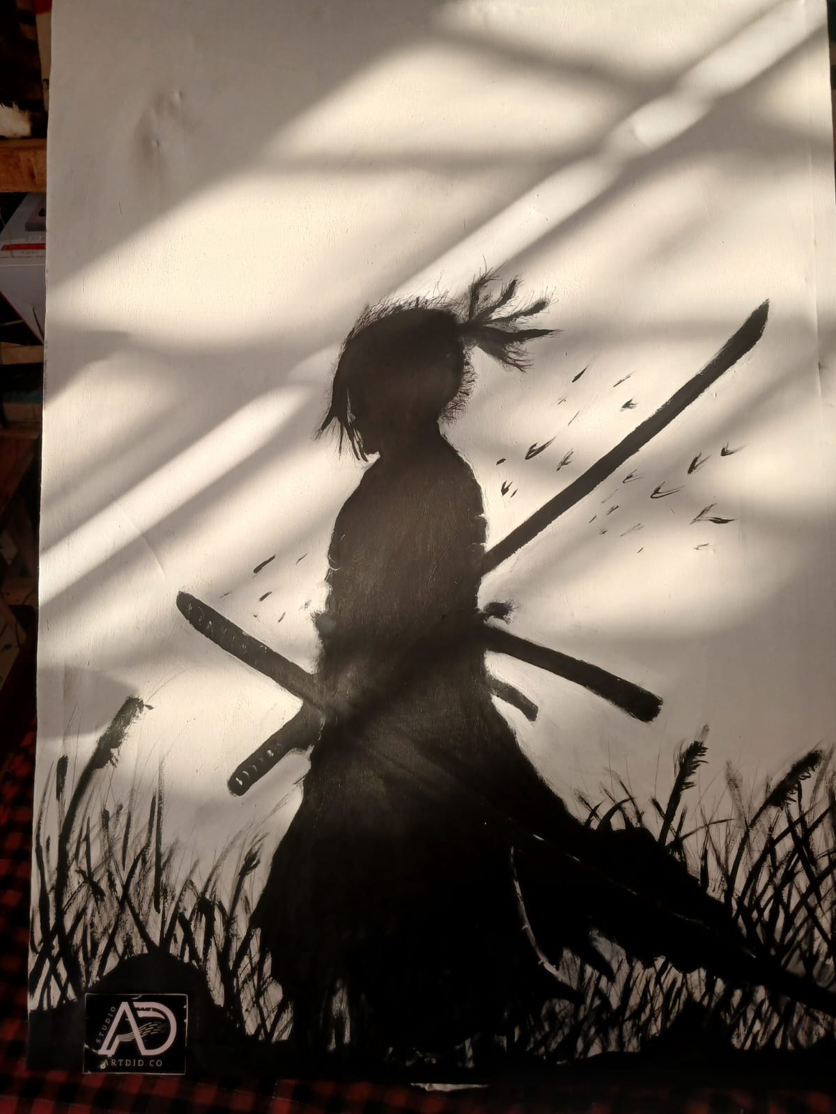 Black silhouette painting of a samurai with two crossed swords walking through tall grass